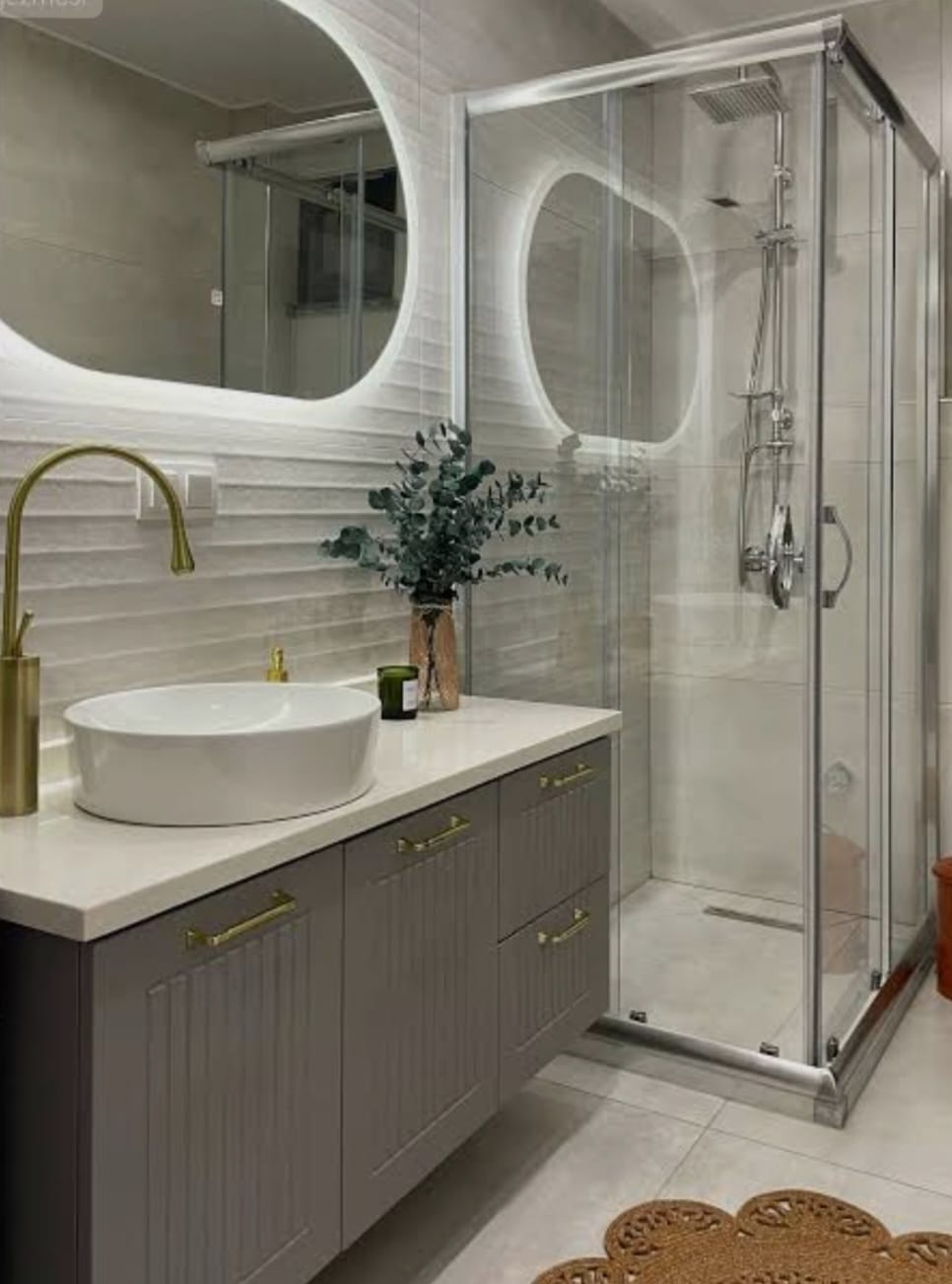 Gri mobilyalı ve cam duş kabinli banyo